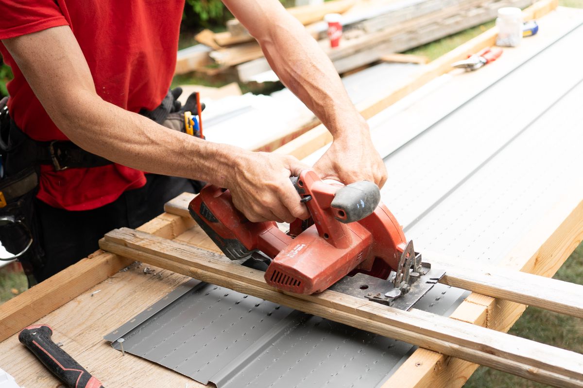 A carpenter working with a power saw on a job