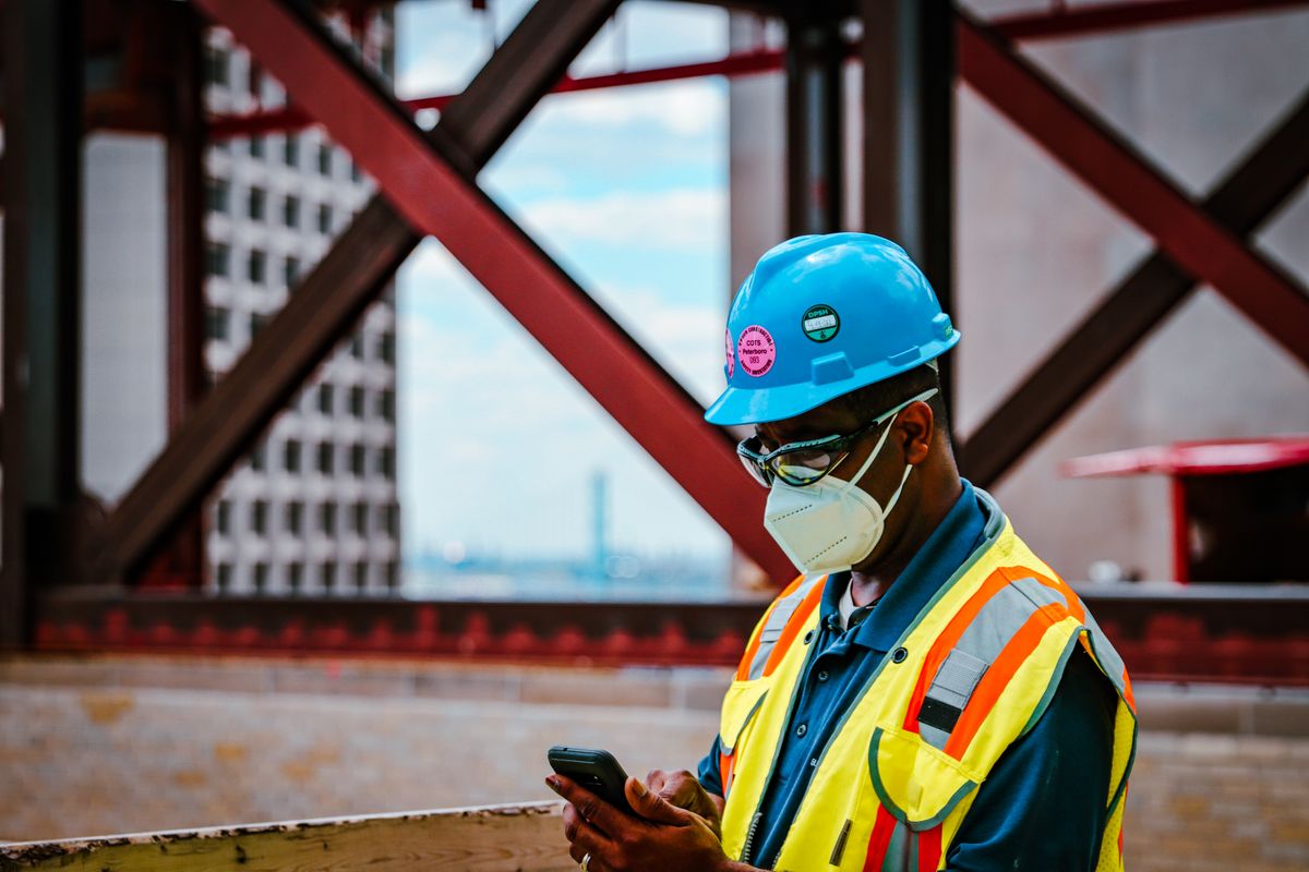 Tradesperson entering job details on a phone on site